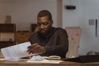 Man in Black Long Sleeve Shirt Holding White Paper