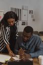 Woman Pointing Pen on Paper to a Man