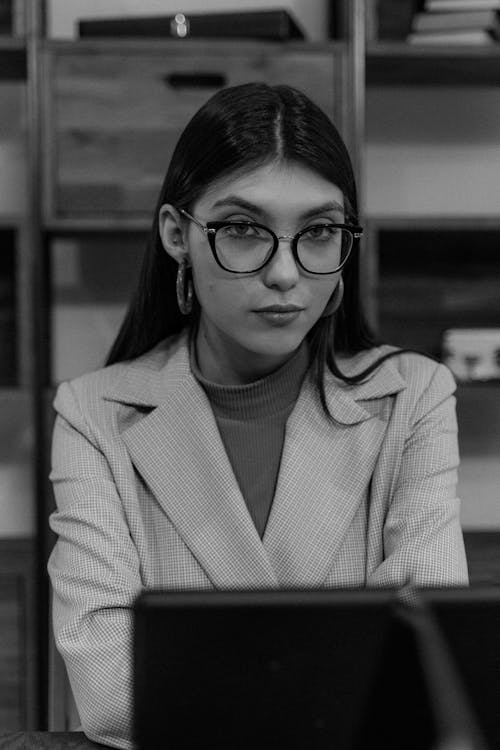Grayscale Photo of Woman in Blazer Wearing Eyeglasses