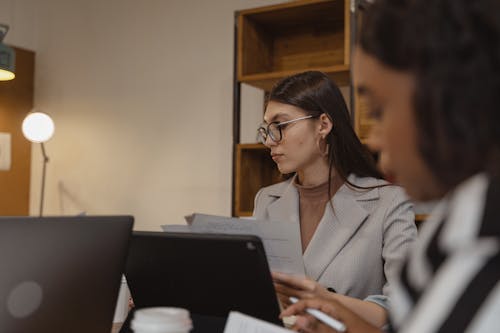 Woman in Gray Blazer Sitting In Front of a Laptop 