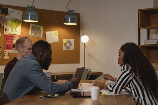 Team of diverse colleagues discussing business strategy in a workplace meeting.