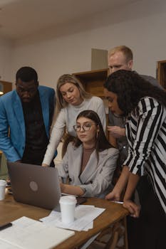 A diverse group of professionals engaged in a collaborative meeting in a modern office setting.