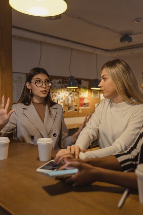 Free A Woman in Gray Blazer Talking to a Woman in White Long Sleeves Stock Photo