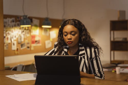 Free Photo of a Woman in a Striped Shirt Working Stock Photo