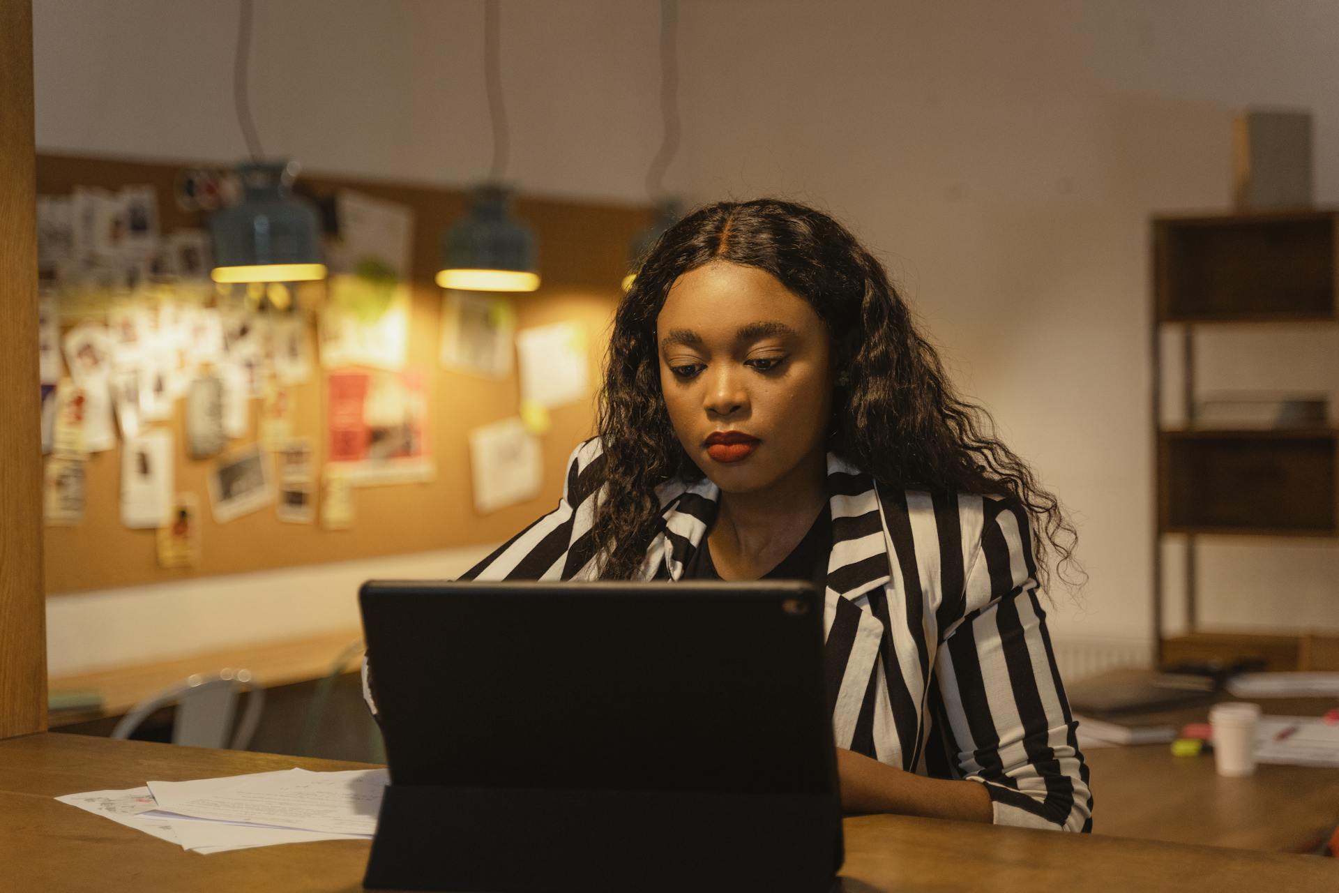 Young African American businesswoman focused on her work in a modern office environment.