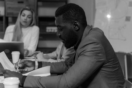 在单色办公室环境中，专注的商人正与同事合作