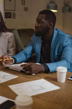 两名专业人士在舒适的咖啡馆里边喝咖啡边讨论工作