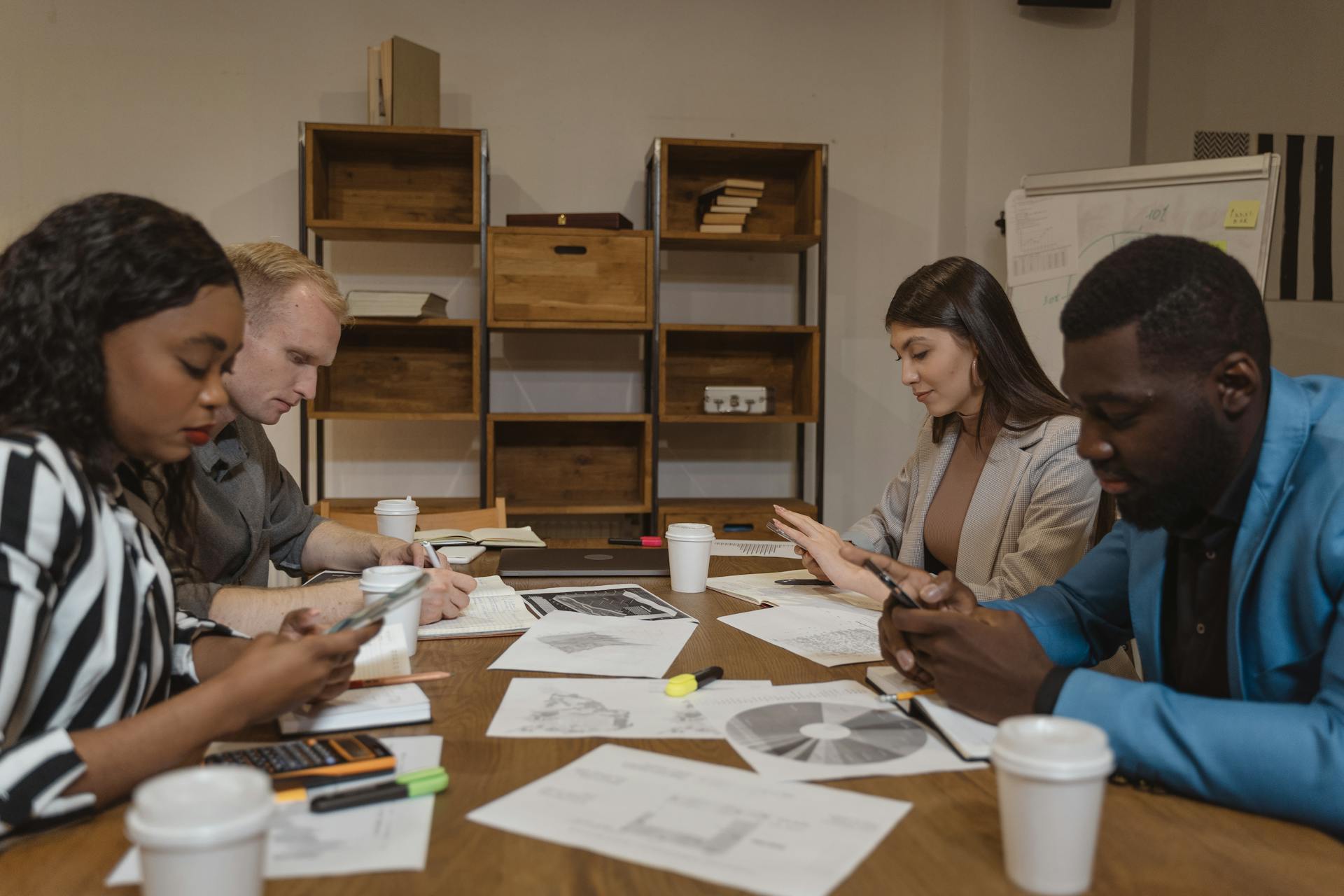 A multicultural team engaged in a focused business meeting in a modern office setting.