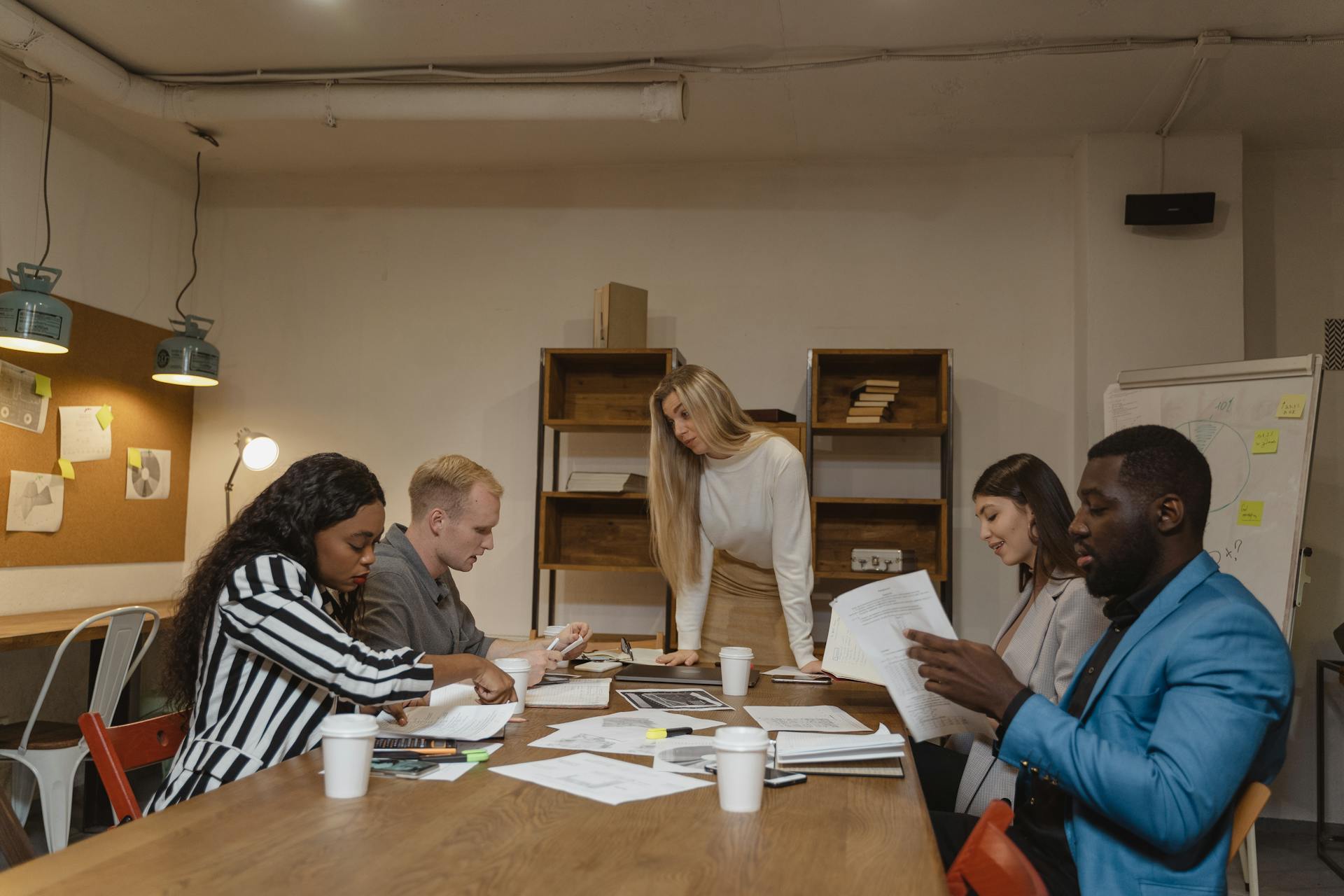 A multicultural group of professionals engaged in a collaborative meeting in a modern office setting.