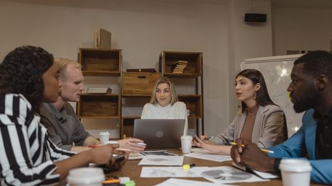 Group of professionals collaborating in a modern office setting during a strategic meeting.
