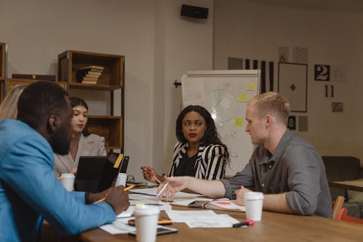 Diverse team engaged in a collaborative meeting in a modern office setting, sharing ideas and working together.