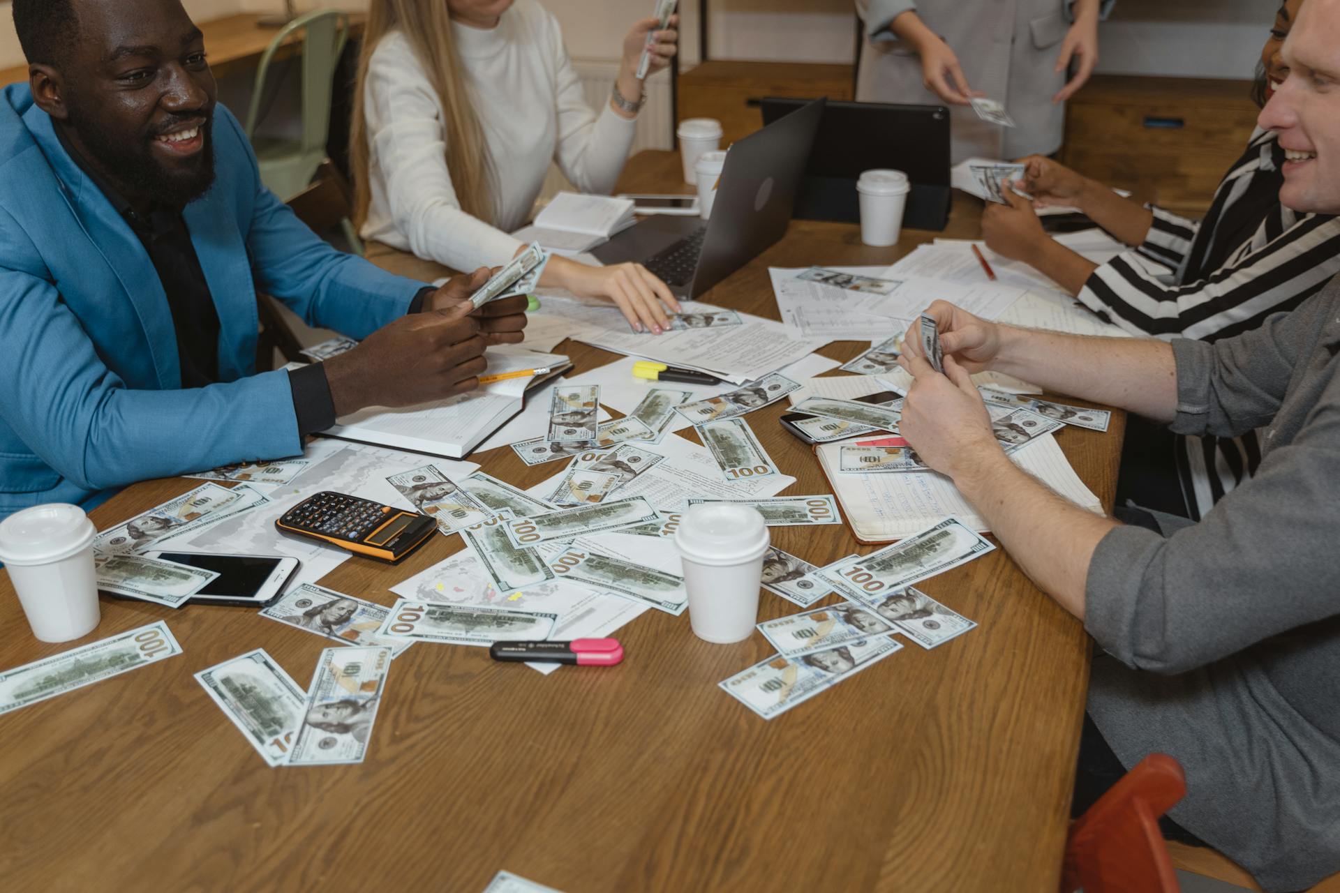 Diverse team in a business meeting discussing strategies with currency on the table.