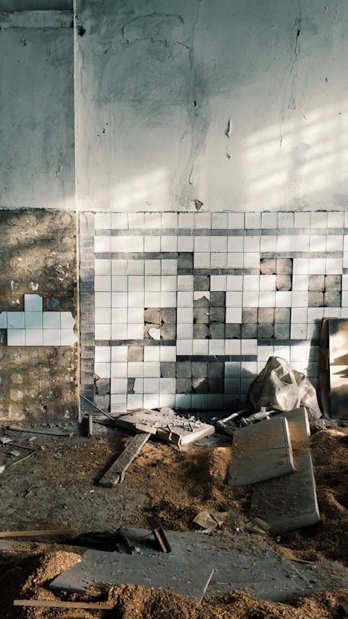 Destroyed Room of a Building with Falling Tiles on Wall