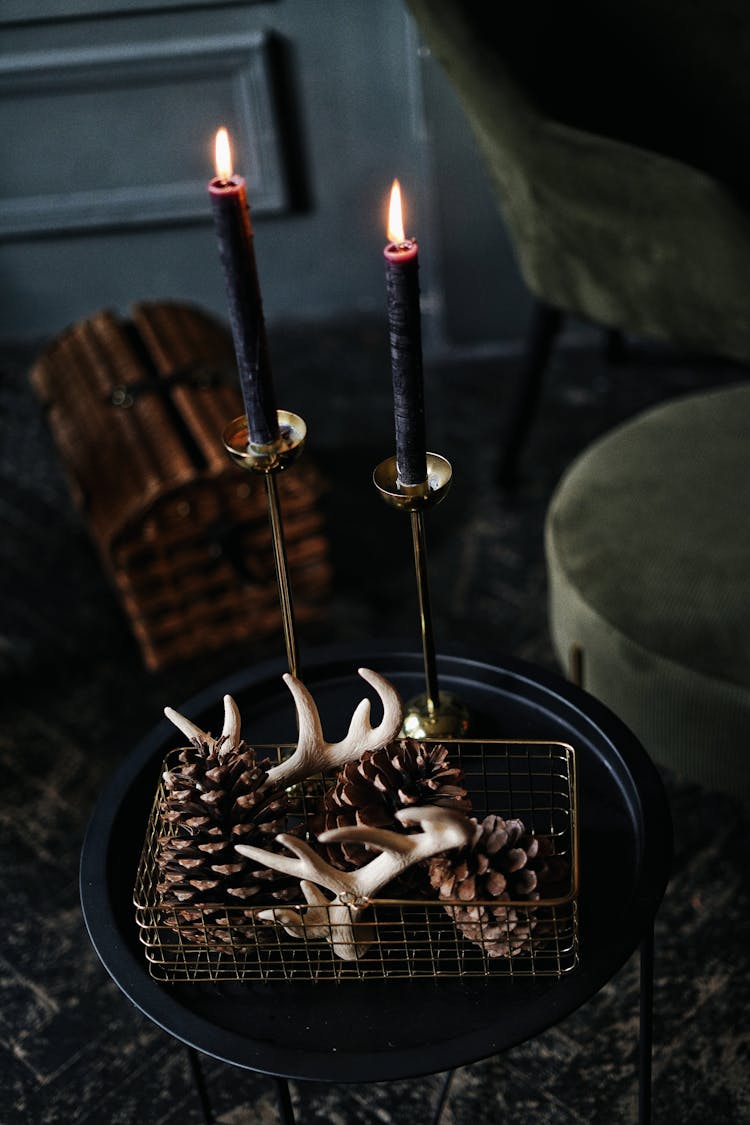 Pinecones And Small Horns On Plate By Candles