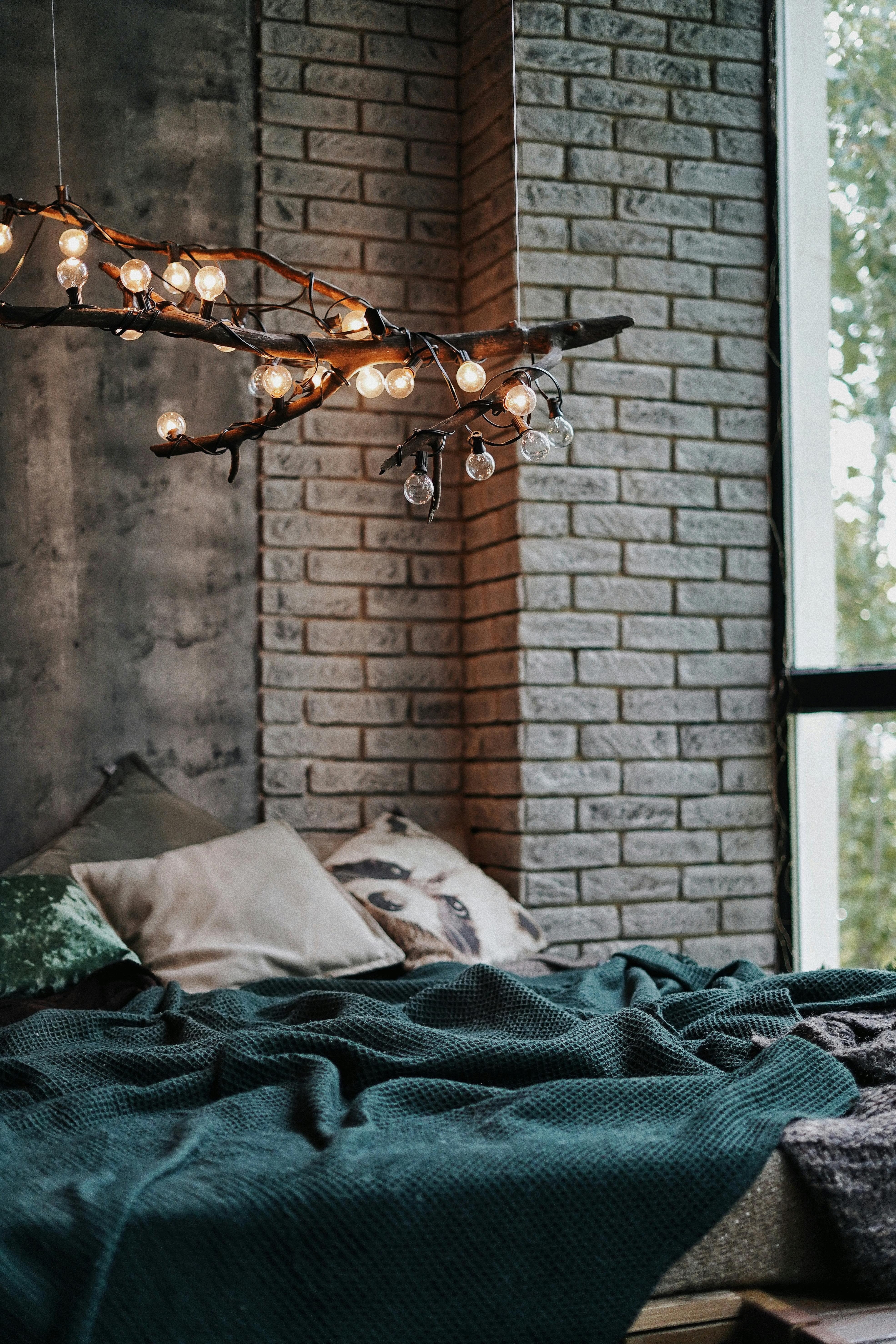 glowing lights on branch in air over bed in room