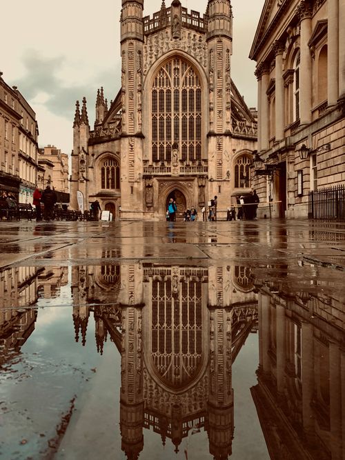 Free Stunning reflection of Gothic Bath Abbey in a puddle, showcasing architectural beauty in England. Stock Photo