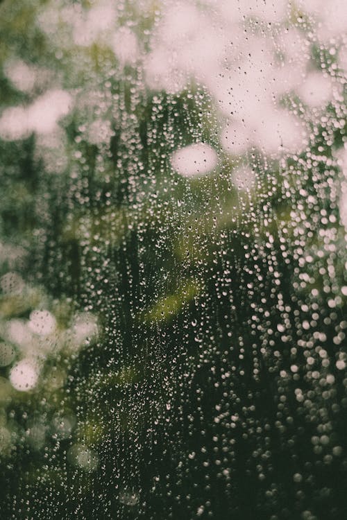 Glass window covered with clear raindrops