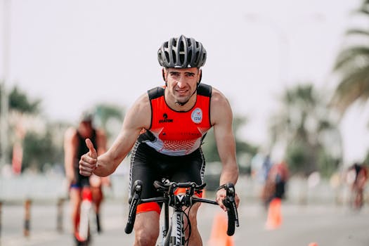 Man in activewear cycling outdoors, expressing confidence with a thumbs up gesture.