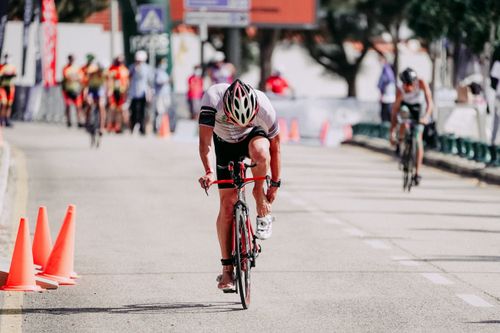 Free Unrecognizable fit sportsmen in helmet riding bicycles on asphalt roadway during competition in city Stock Photo