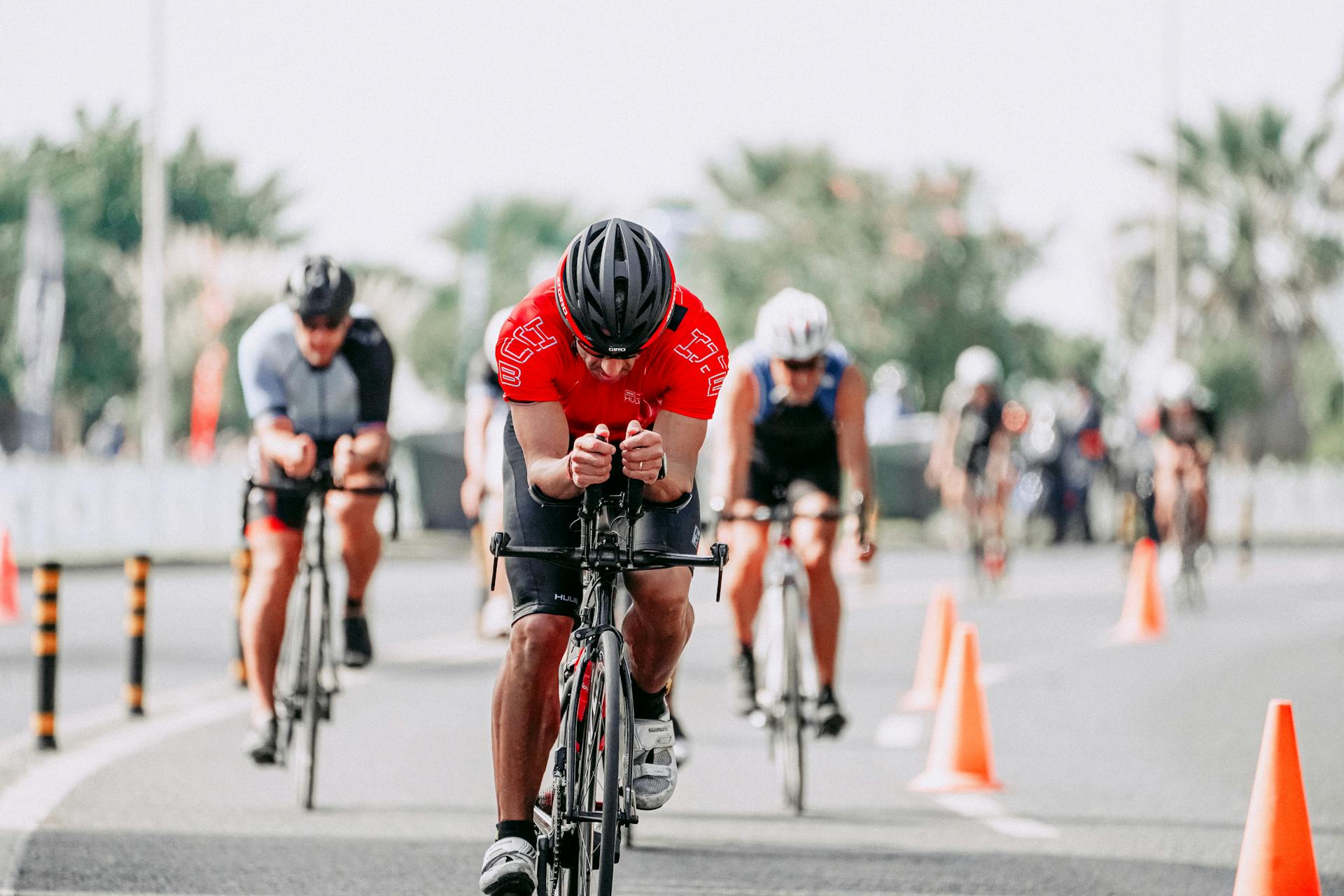 Unrecognizable cyclists riding bikes on road during race