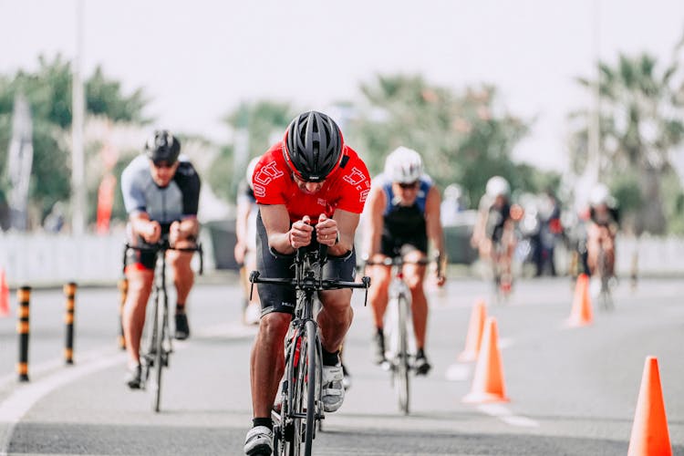 Unrecognizable Cyclists Riding Bikes On Road During Race