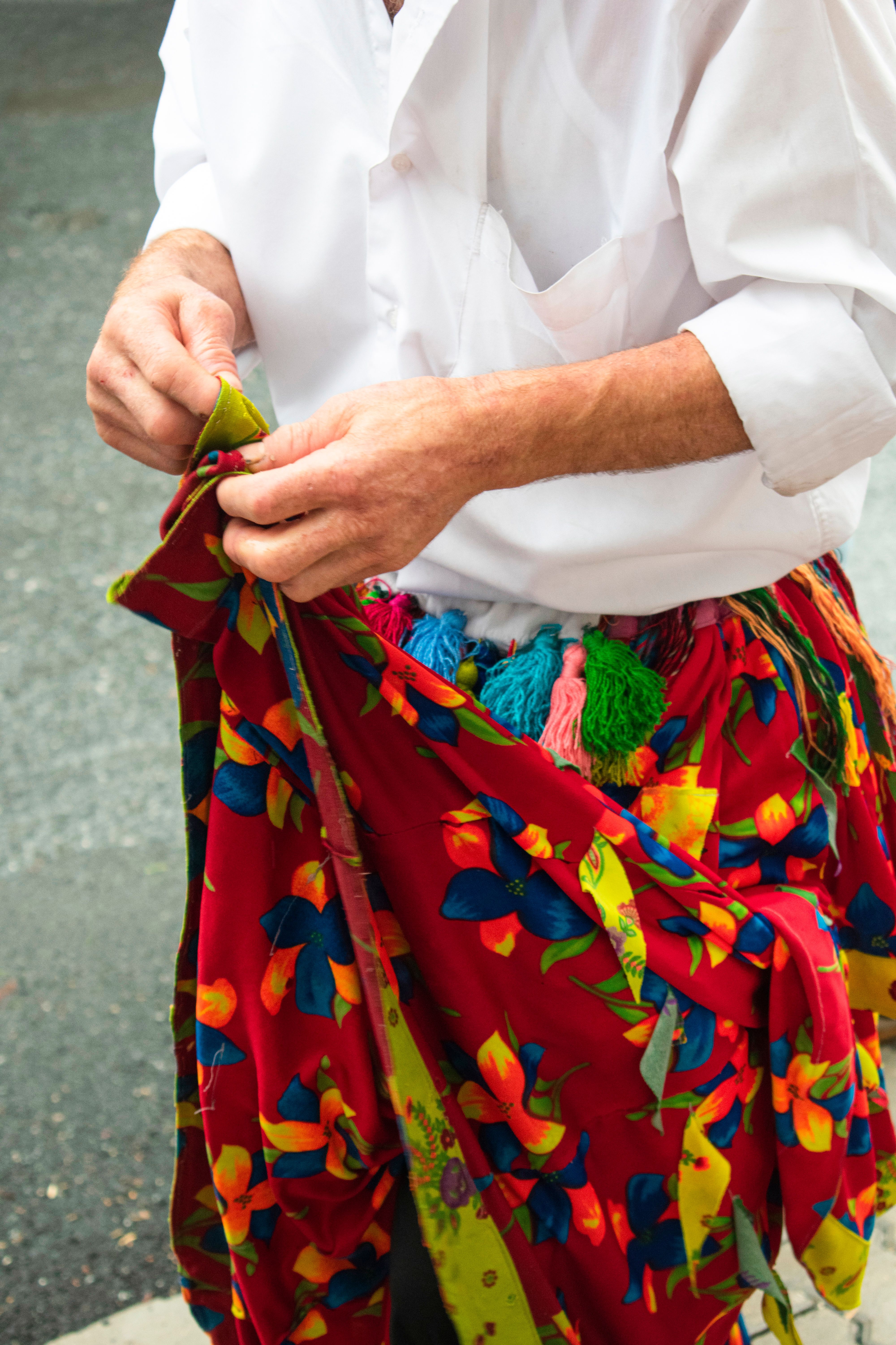 Close-up of a person adjusting a vibrant floral skirt, showcasing cultural attire in Istanbul, Turkey.