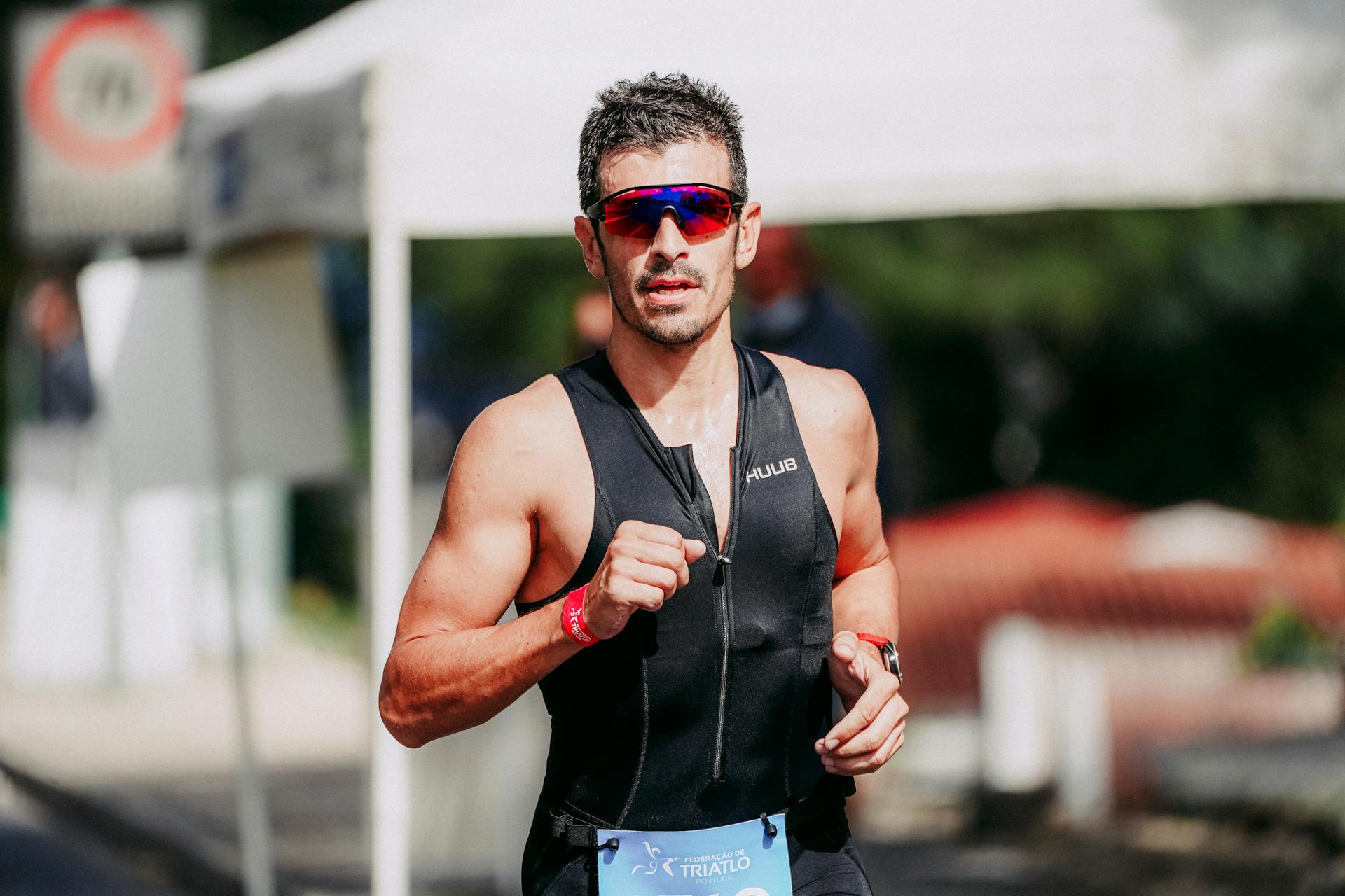 A determined male athlete in sportswear participating in a triathlon outdoors.