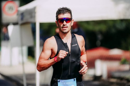 Free Serious young man in protective glasses and sportswear running on street during marathon and looking at camera Stock Photo