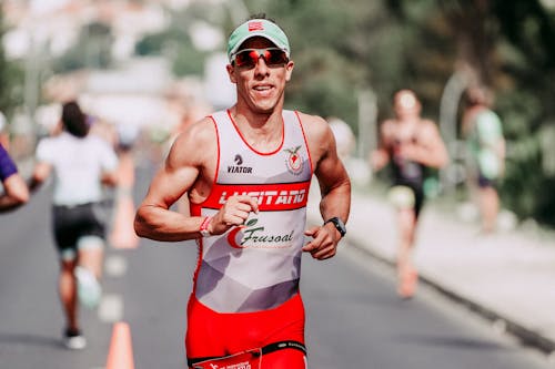 Happy sportsman running on asphalt track