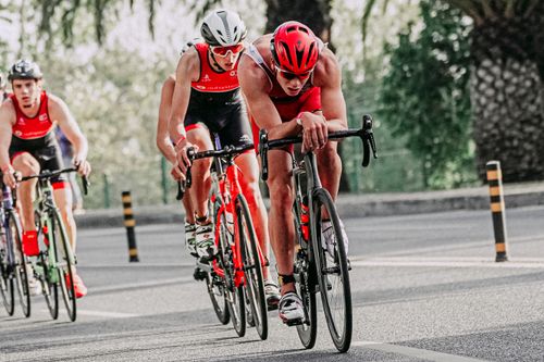 Free Full body of group of athletes in sportswear and protective helmets riding bicycles during competition Stock Photo