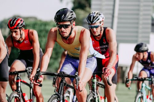 Free Group of people in protective helmets and sportswear riding bicycles on asphalt road during competition Stock Photo