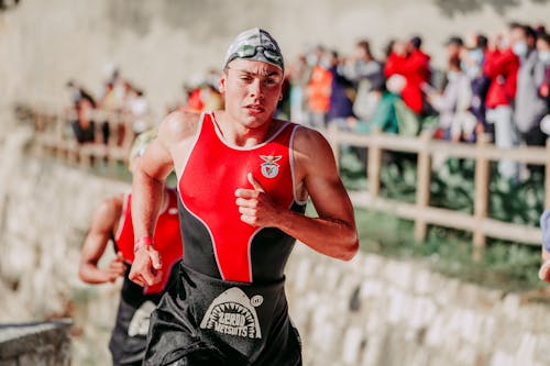 Muscular sportsman running after swimming during competition