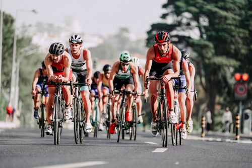 Free Full body of group of athletes in helmet and sportswear riding bicycles on asphalt road during race Stock Photo