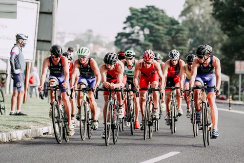 Free Group of cyclists in helmets riding professional bicycles fast on track during race Stock Photo