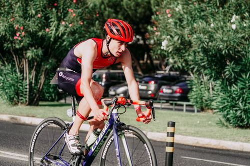 Free Young concentrated cyclist in helmet and sportswear riding professional bicycle on asphalt road Stock Photo