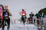 Back view of faceless group of people in wet sportswear running barefoot while taking part in competition