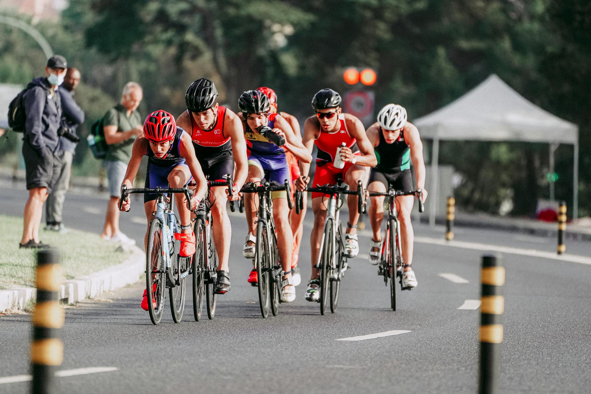 A dynamic group of cyclists racing in a professional road competition outdoors during the day.