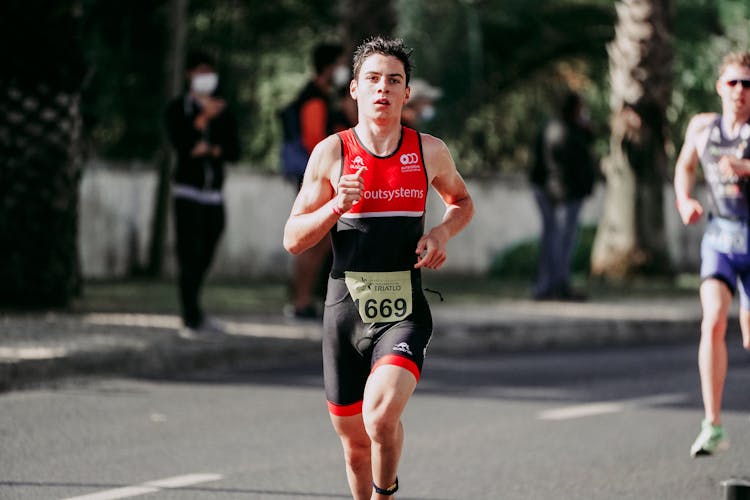 Muscular Runner On Paved Road In Daytime