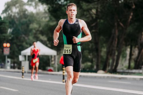 Free Concentrated young sportsman in jogging suit looking at camera while running on asphalt road in daytime on blurred background Stock Photo