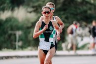 Focused women in sunglasses running with arms raised