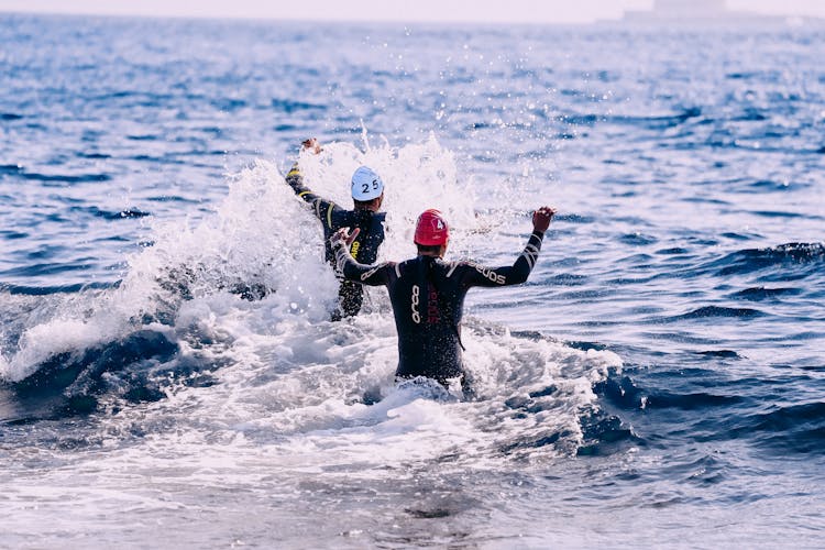 Faceless People Running Into Ocean In Daytime