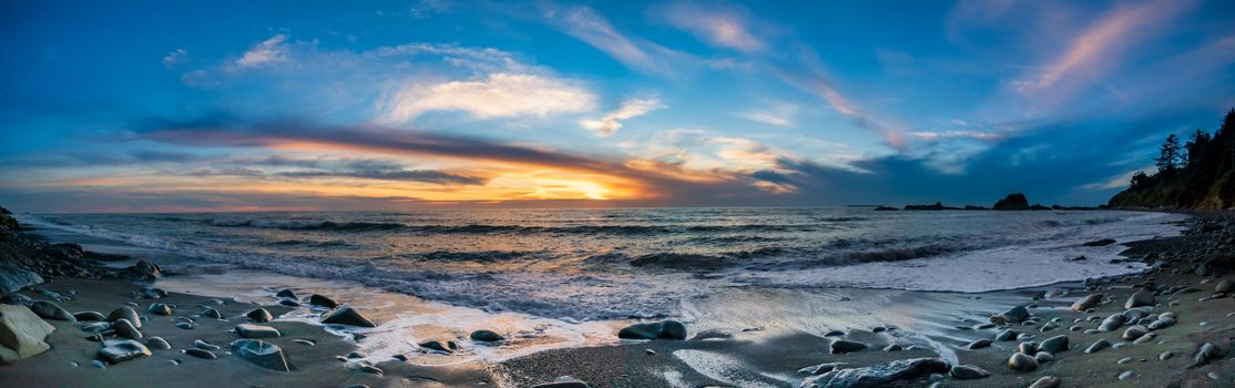 Captivating sunset at a rocky beach, showcasing vibrant skies and crashing ocean waves.