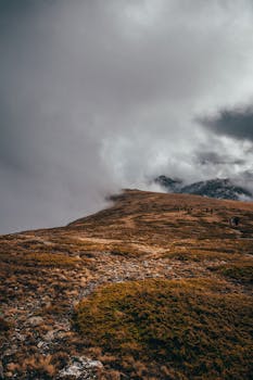 雾气缭绕的山路消失在低云中，这风景非常适合户外冒险主题