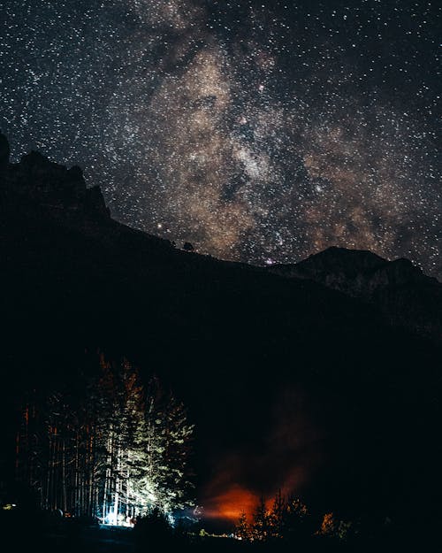Silhouette of Mountain Under a Starry Sky during Night Time