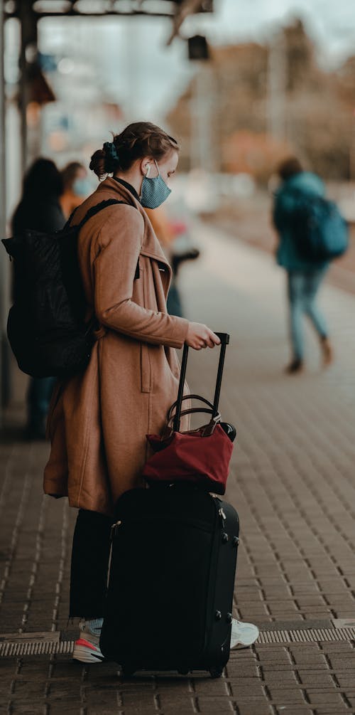 Woman In Brown Coat Carrying A Backpack