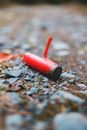 Massive red bullet on ground with stones