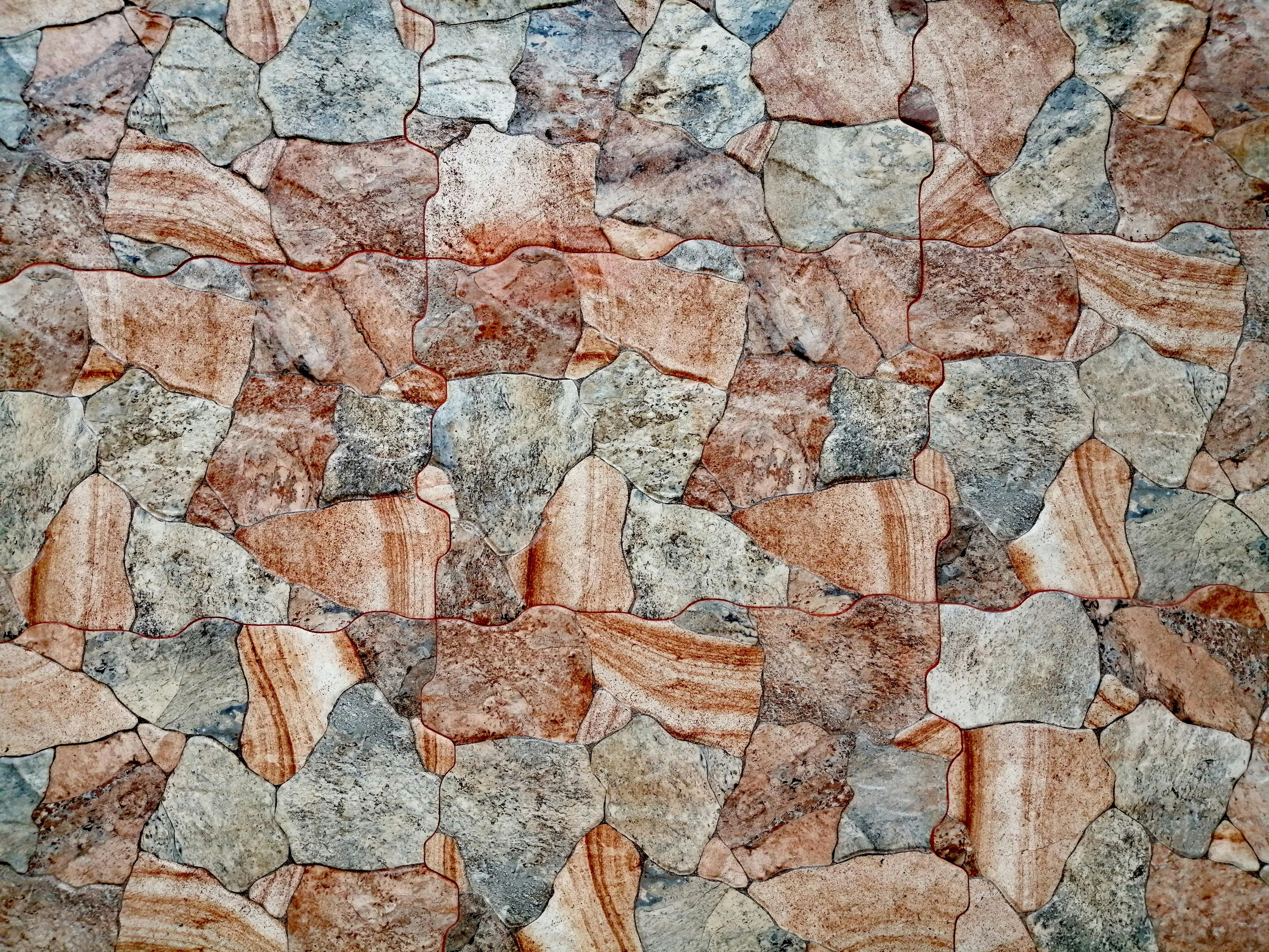 Detailed close-up texture of a vibrant stone wall in San Salvador, showcasing natural patterns.