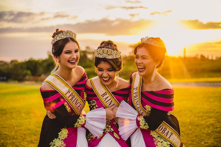 Positive Ethnic Beauty Contest Winners In Stylish Wear In Sunshine