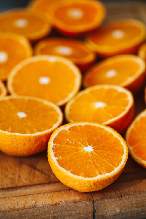 Free Close-up of vibrant orange slices displaying freshness on a wooden table. Stock Photo