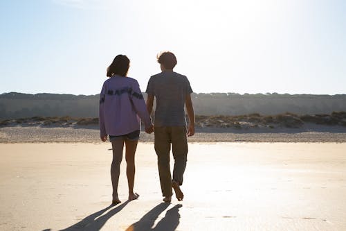 Couple Walking Barefoot on Sand